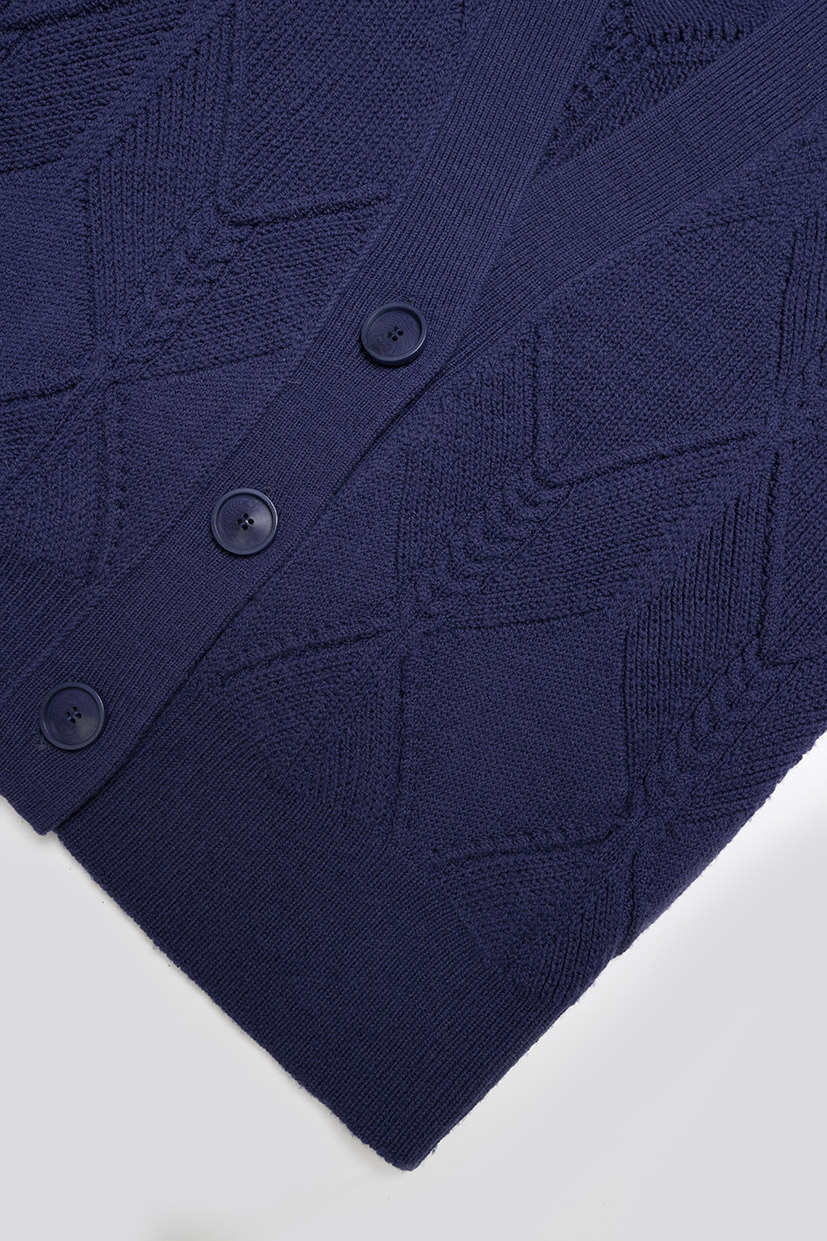 gros plan sur une veste en laine tricotée couleur bleu marine à gros boutons